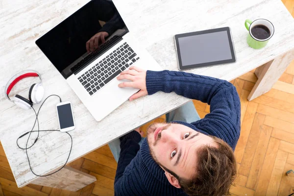 Ein junger Mann, der online im Home Office arbeitet — Stockfoto