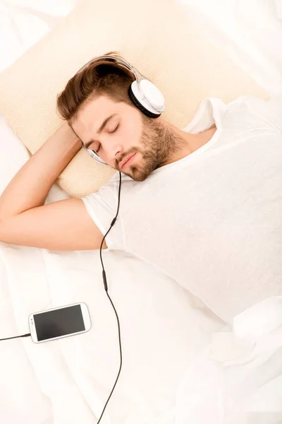Lyssnar musik i sängen. — Stockfoto