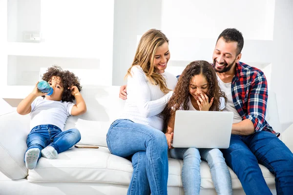 Familia joven sentada en el sofá — Foto de Stock