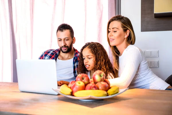 Familia joven sentada a la mesa — Foto de Stock