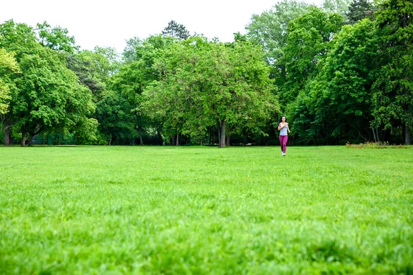 Beautiful young sporty girl in a park — Stock Photo, Image