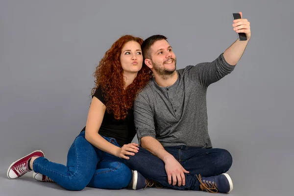 Bonita pareja joven sentada en el estudio — Foto de Stock