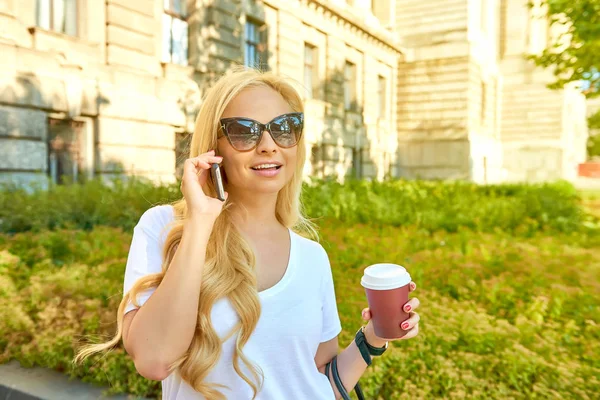 Młoda kobieta na kawę i rozmawia przez telefon — Zdjęcie stockowe