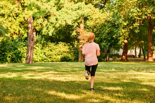 Jeune femme courant sur un terrain — Photo