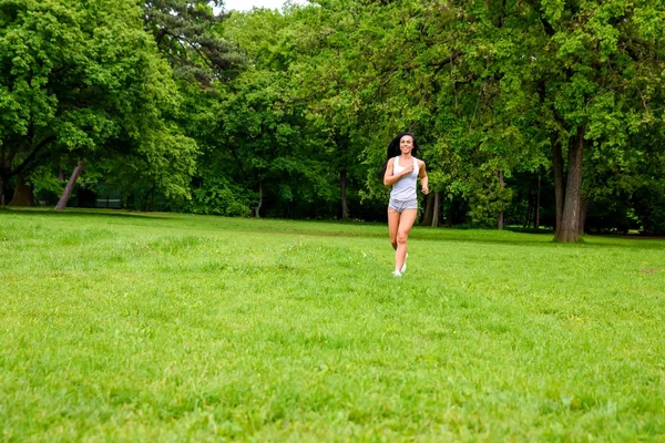 Beautiful young sporty girl in a park — Stock Photo, Image