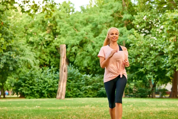 Young woman running on a field — Stock Photo, Image