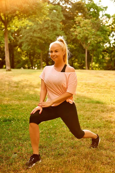 Jonge vrouw die zich uitstrekt op het veld — Stockfoto