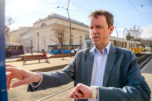 Een zakenman van middelbare leeftijd bij de tramhalte — Stockfoto