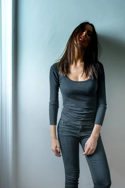 Mörkt humör porträtt av en kvinna framför en vägg — Stockfoto