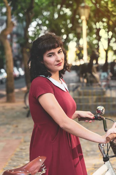 빨간 드레스를 입고 자전거를 탄 미소짓는 여자 — 스톡 사진
