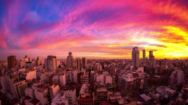 アルゼンチンのブエノスアイレスの沈む太陽の光を受けて カラフルな雲が通り過ぎる都市のスカイラインのタイムラプスビュー — ストック動画