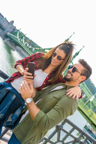 Пара в городе наслаждается содержимым своего мобильного телефона — стоковое фото