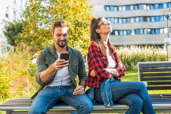 Uma namorada sendo irritado por seus namorados uso de smartphones . — Fotografia de Stock