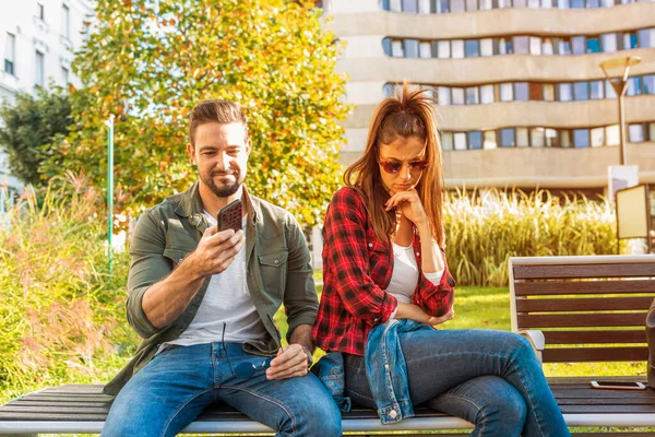 A girlfriend being annoyed by her boyfriends smartphone usage. — Stock Photo, Image
