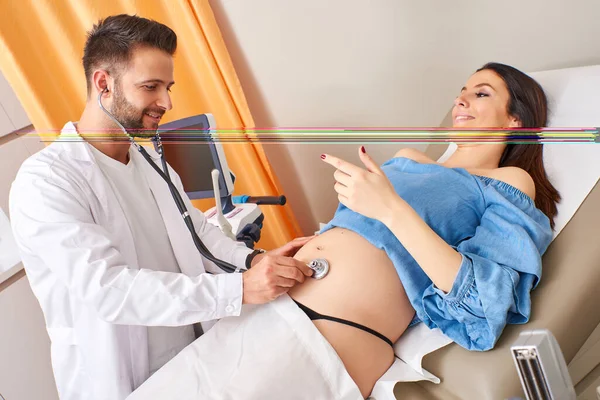 Examinando uma mulher grávida com um estetoscópio — Fotografia de Stock