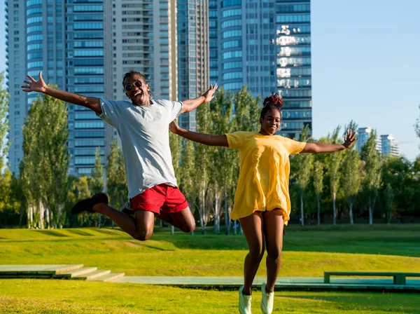Ένα ευτυχισμένο ζευγάρι που πηδάει στο πάρκο της πόλης. — Φωτογραφία Αρχείου