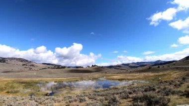 Yellowstone Ulusal Parkı 'ndaki Lamar Vadisi' ndeki bir göletin zamanı. Kamera sağdan sola dönüyor.