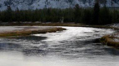 Madison Nehri batı Yellowstone Ulusal Parkı 'nda sonbaharda hafif bir kar tozu ile. Kamera sağdan sola geçiyor.