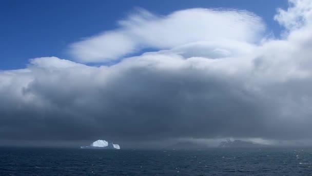 南極のエレファント島の近くの氷山は 上の青い空で 戦略的な雲と霧を背景にしています ゆっくりと動く船に固定されたカメラ — ストック動画