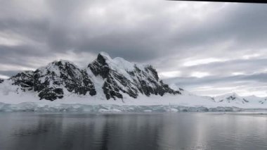 Antarktika Yarımadası 'ndaki Lemaire Adası. Hareket halindeki bir gemiye yerleştirilen kamera soldan sağa hareket ettiriyor..