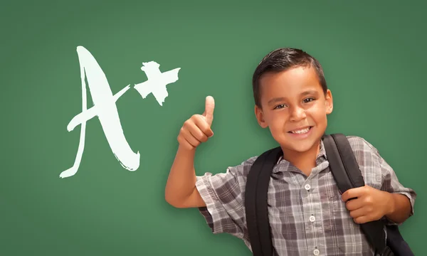 Hispanique garçon avec les pouces vers le haut en face de A + Ecrit sur le sanglier à craie — Photo