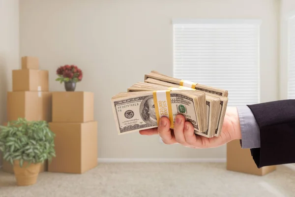 Entregando sobre o dinheiro no quarto com caixas móveis embaladas — Fotografia de Stock