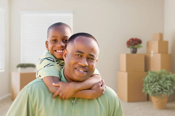 Afro-Américain père et fils dans la chambre avec des boîtes mobiles emballées — Photo