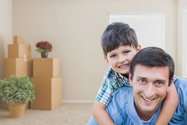 Padre e figlio in camera con scatole mobili imballate e pianta in vaso — Foto Stock