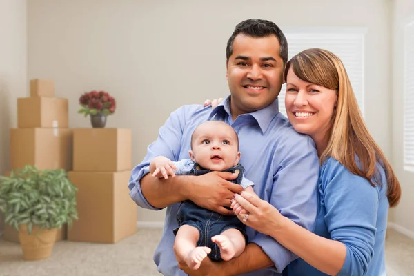 Famiglia mista con bambino in camera con scatole mobili imballate — Foto Stock