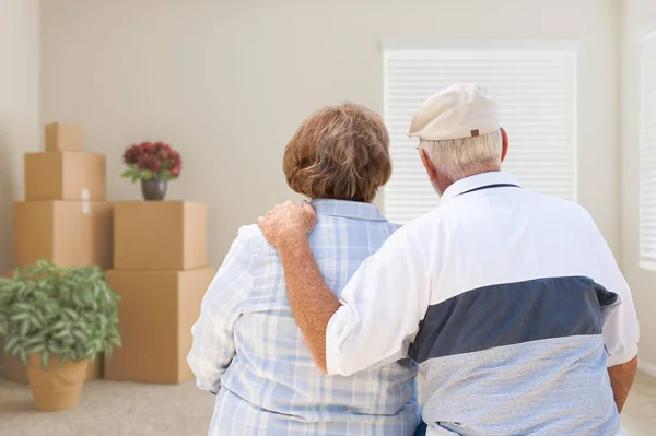 Camera vuota di fronte alla coppia anziana con scatole mobili imballate e vaso — Foto Stock