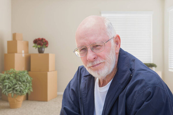 Senior Man in Empty Room with Packed Moving Boxes