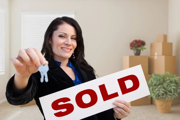 Hispanic Female Real Estate Agent with Sold Sign and Keys in Roo Stock Picture