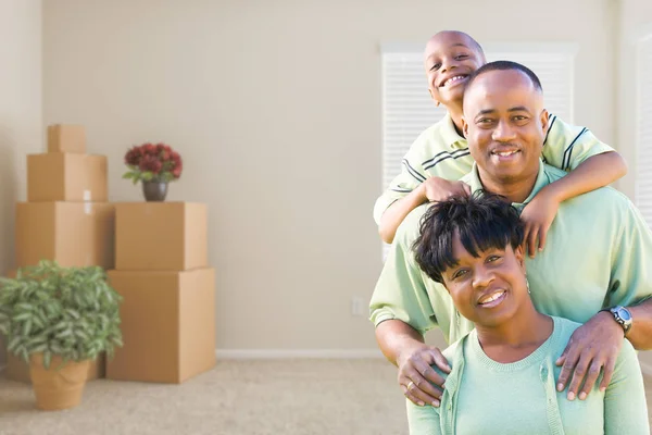Famille afro-américaine dans la chambre avec boîtes de déménagement emballées — Photo