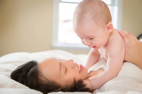 Mixte race chinois et caucasien bébé garçon couché dans son lit avec son — Photo