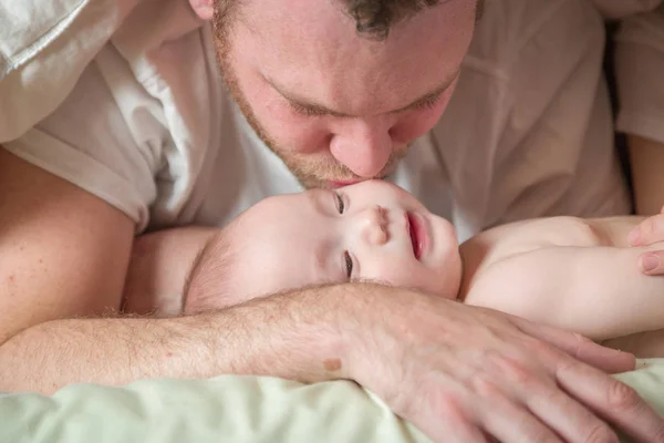 Chinesische und kaukasische Mischlingsbabys liegen mit ihren Eltern im Bett — Stockfoto