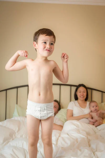 Mixed Race Chinese and Caucasian Boy Jumping In Bed with His Fam — Stock Photo, Image