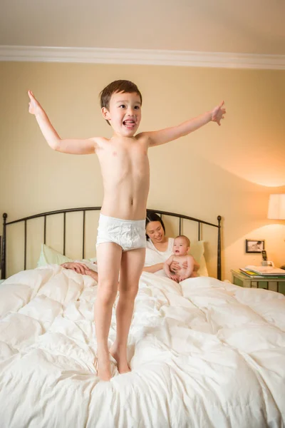 Mixed Race Chinese and Caucasian Boy Jumping In Bed with His Fam — Stock Photo, Image