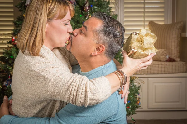 Jeune couple de race mixte avec présent près de l'arbre de Noël — Photo