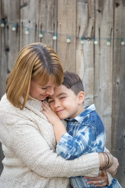 Moeder en gemengde Race zoon knuffel in de buurt van hek — Stockfoto