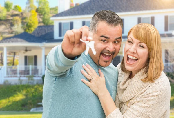 Casal de raça mista feliz na frente da casa com novas chaves — Fotografia de Stock