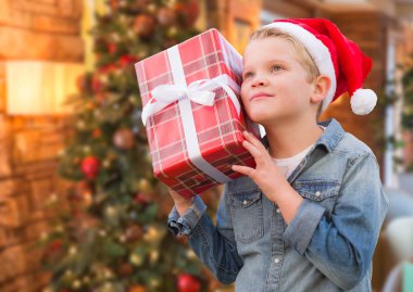 Noel Baba Noel hediyesi ağacı önünde Holding şapkası giyen çocuk