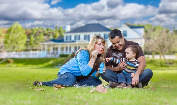 Etnische familie gelukkig gemengd ras spelen met bubbels vooraan Yar — Stockfoto