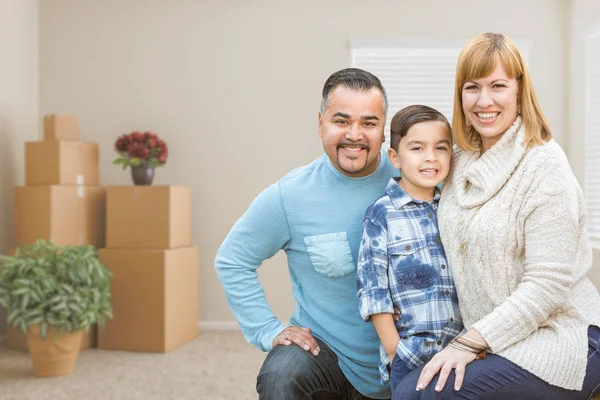 Familia de raza mixta con hijo en la habitación con cajas móviles llenas — Foto de Stock