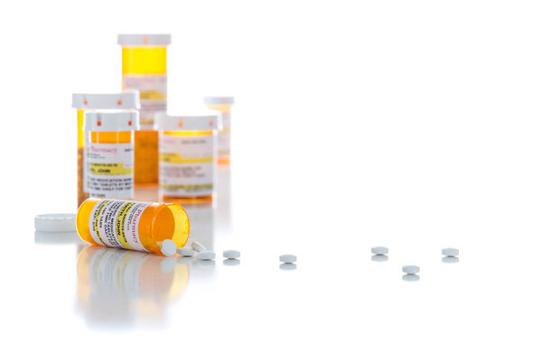 Non-Proprietary Medicine Prescription Bottles and Spilled Pills Isolated on White