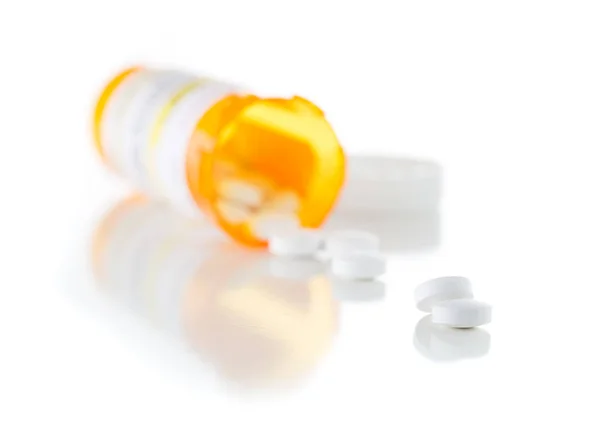 Непроприетарная медицина Бутылка рецепта и пролитые таблетки изолированы на белом — стоковое фото