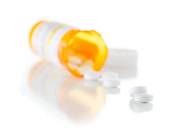 Non-Proprietary Medicine Prescription Bottle and Spilled Pills Isolated on White