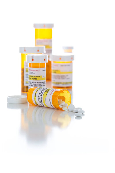 Non-Proprietary Medicine Prescription Bottles and Spilled Pills Isolated on White