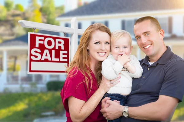 Joven familia militar en frente de en venta signo y casa — Foto de Stock