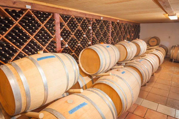 Barriles y botellas de vino Edad dentro de la bodega — Foto de Stock