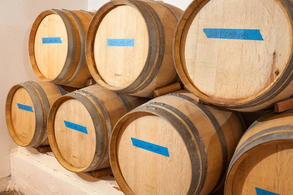 Wine Barrels and Bottles Age Inside Dark Cellar. — Stock Photo, Image